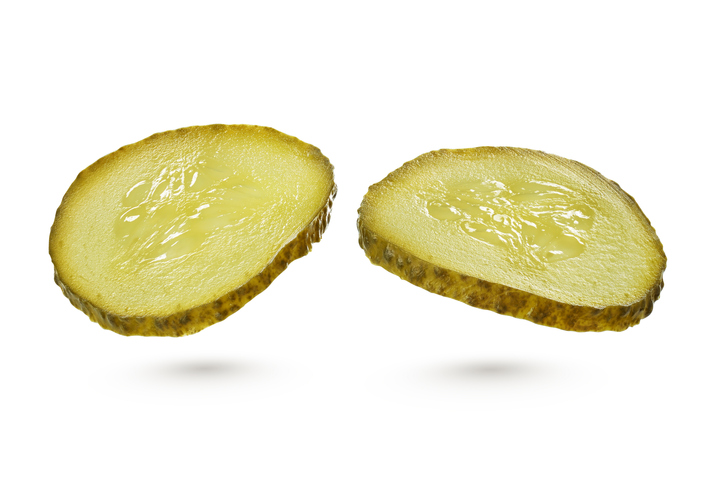 Two sliced green pickles isolated on white background with clipping path